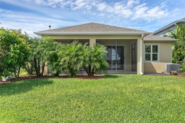 back of house with a yard, a sunroom, and central AC