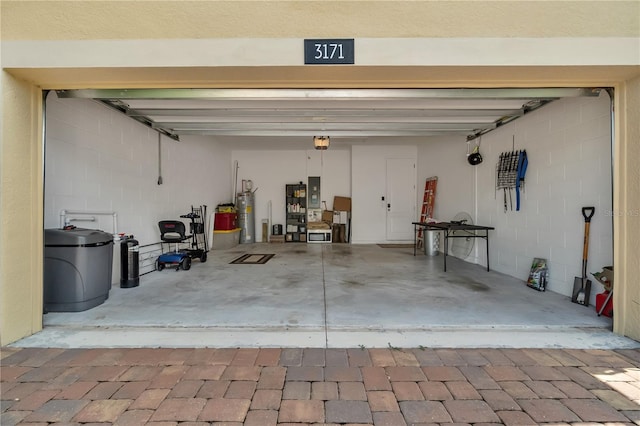 garage with a garage door opener, electric panel, and water heater