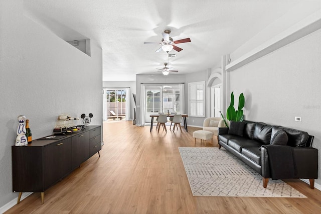 living room featuring light hardwood / wood-style floors and ceiling fan