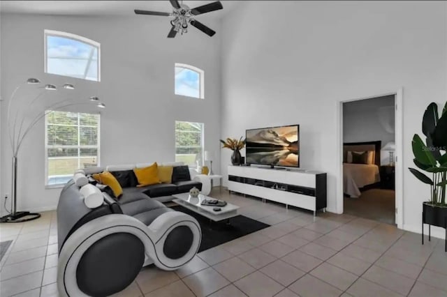 tiled living room featuring ceiling fan and high vaulted ceiling