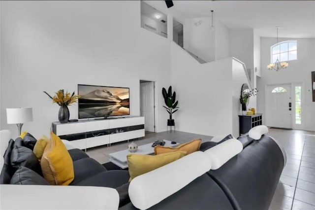 tiled living room with a chandelier and high vaulted ceiling