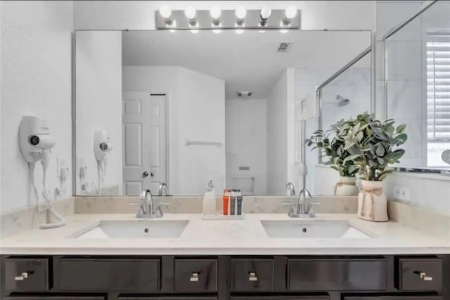 bathroom with vanity and a shower with shower door