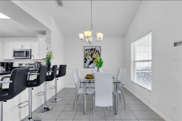 dining space featuring vaulted ceiling, light tile patterned floors, and a notable chandelier