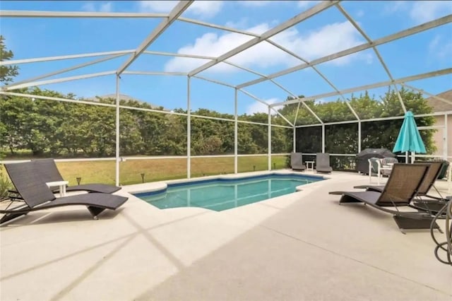 view of swimming pool with glass enclosure and a patio