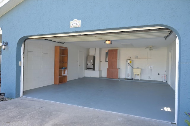 garage featuring electric water heater, sink, a garage door opener, and heating unit