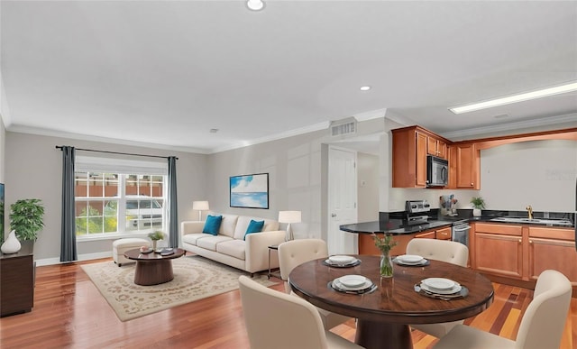 dining space with crown molding, recessed lighting, visible vents, light wood-style floors, and baseboards