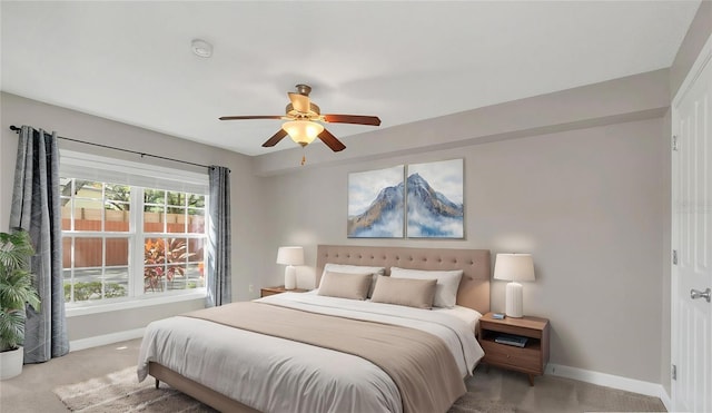 bedroom featuring light carpet, baseboards, and a ceiling fan