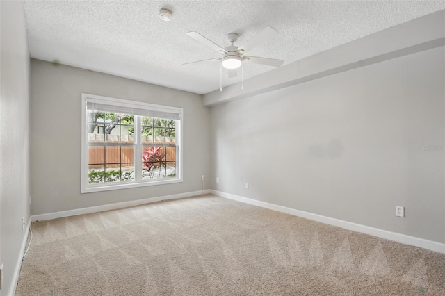 spare room featuring carpet, baseboards, and a textured ceiling