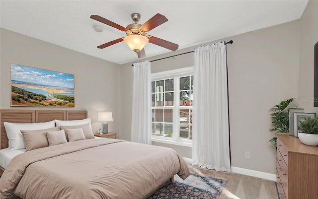 bedroom featuring light carpet, ceiling fan, and baseboards