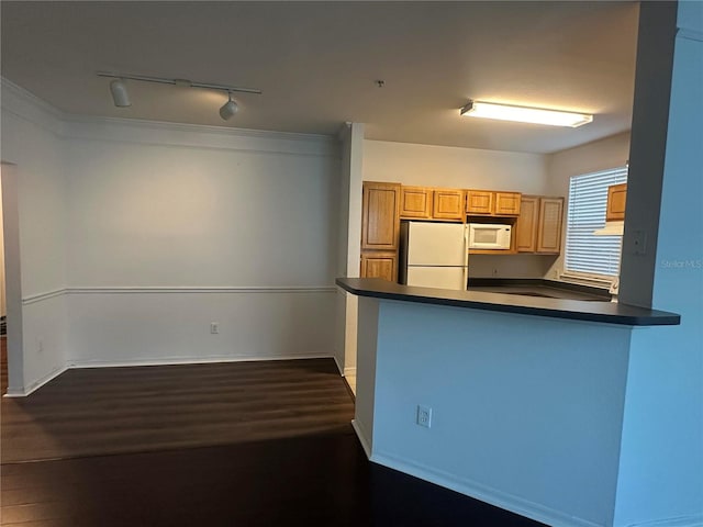 kitchen with light brown cabinets, kitchen peninsula, white appliances, and rail lighting