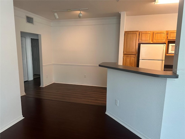 kitchen with rail lighting, light brown cabinets, dark hardwood / wood-style floors, white fridge, and ornamental molding