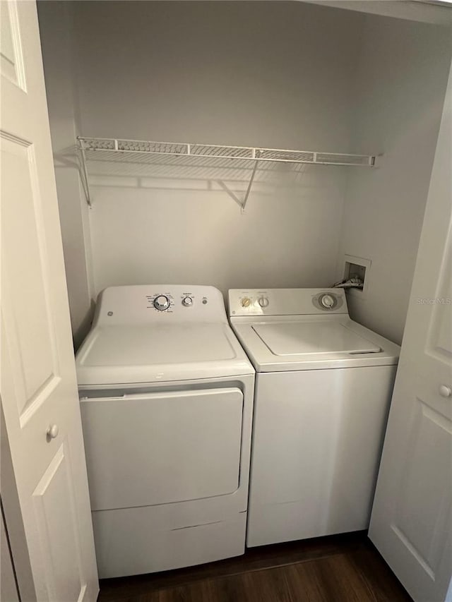 laundry area featuring washing machine and dryer and dark hardwood / wood-style flooring