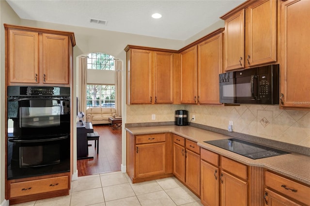 kitchen with light hardwood / wood-style flooring and black appliances