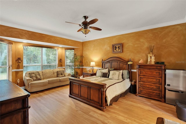 bedroom featuring ceiling fan, light wood-type flooring, and ornamental molding