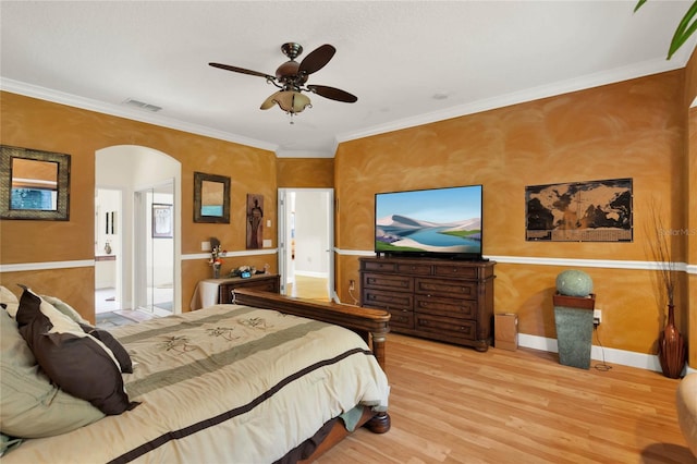 bedroom with light wood-type flooring, ornamental molding, and ceiling fan