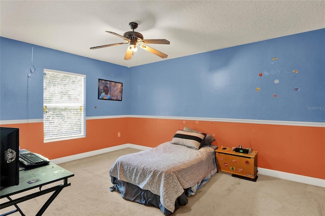 carpeted bedroom featuring ceiling fan and a textured ceiling