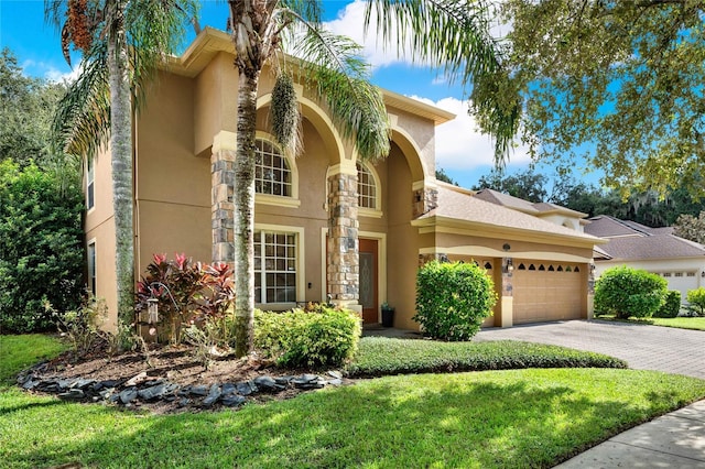 mediterranean / spanish home featuring a front lawn and a garage