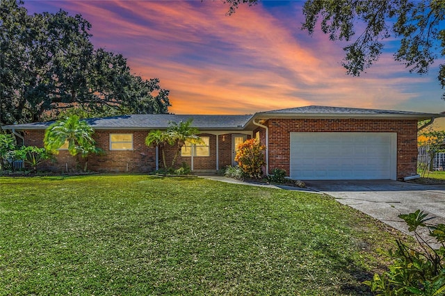 ranch-style house with a yard and a garage