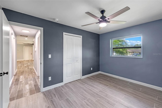 unfurnished bedroom with ceiling fan, light hardwood / wood-style floors, and a closet