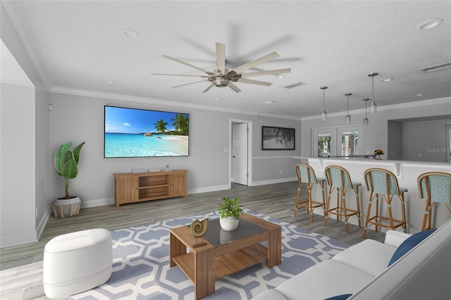 living room with crown molding, french doors, ceiling fan, and light hardwood / wood-style floors