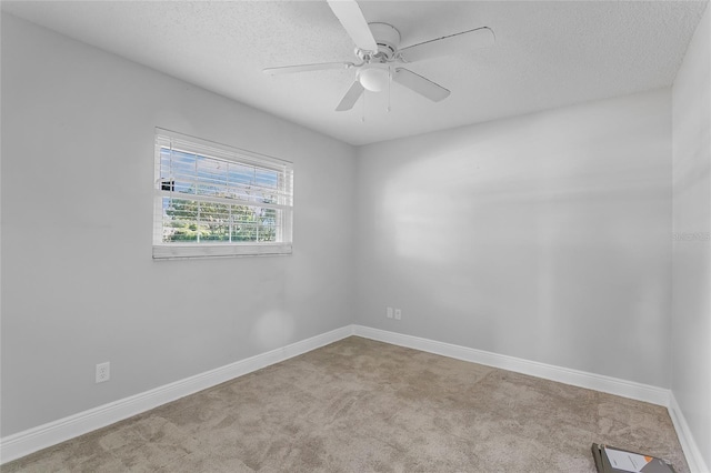 carpeted spare room with a textured ceiling and ceiling fan