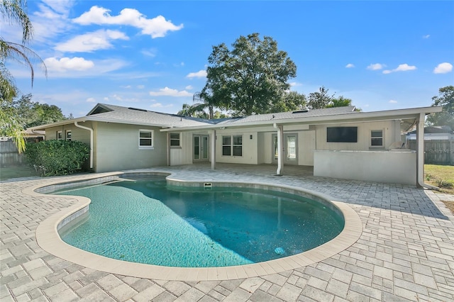 rear view of house with a patio area and a fenced in pool