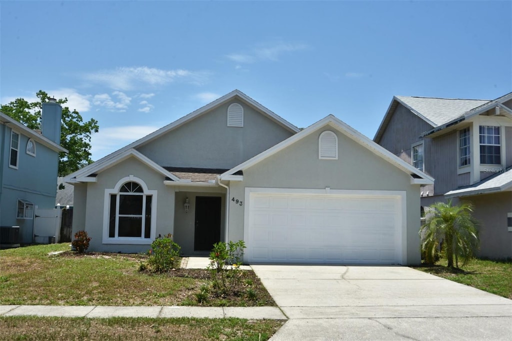 view of property featuring central AC unit and a garage