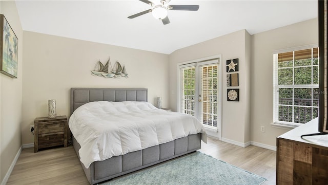 bedroom featuring ceiling fan, light hardwood / wood-style floors, multiple windows, and access to exterior