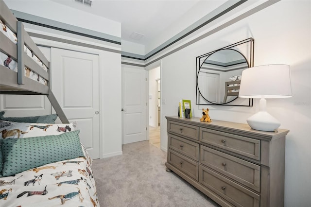 bedroom featuring light colored carpet and a closet