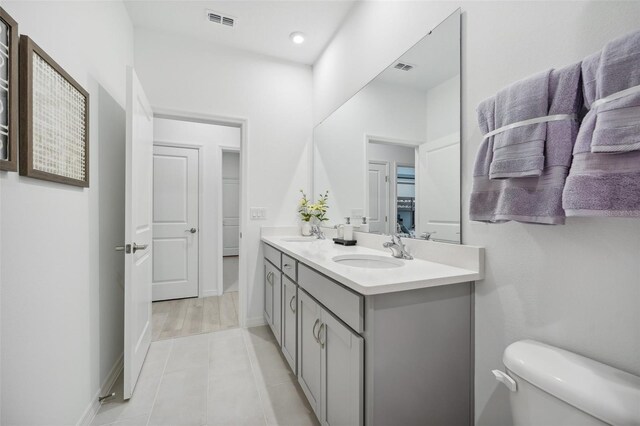 bathroom with tile patterned flooring, vanity, and toilet