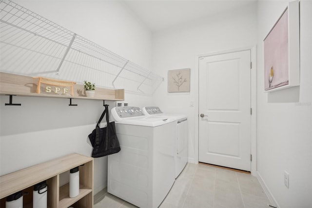 clothes washing area featuring light tile patterned floors and washing machine and clothes dryer