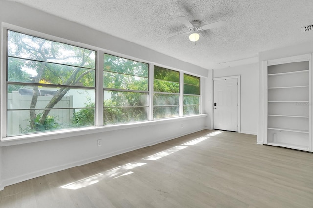 spare room with a textured ceiling, light hardwood / wood-style flooring, and ceiling fan