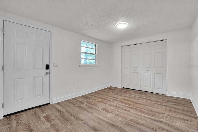 entrance foyer with a textured ceiling and light wood-type flooring