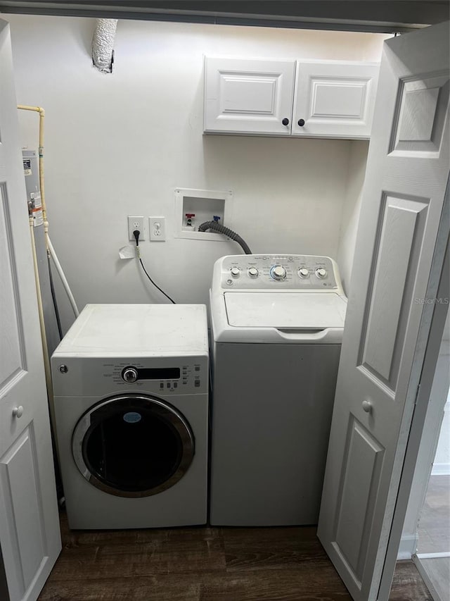 washroom featuring cabinets, washing machine and dryer, and dark hardwood / wood-style floors