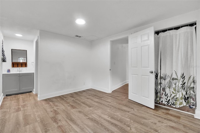 unfurnished room featuring light wood-type flooring and sink