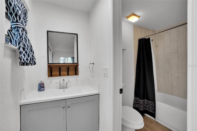 full bathroom featuring shower / tub combo, vanity, a textured ceiling, hardwood / wood-style floors, and toilet