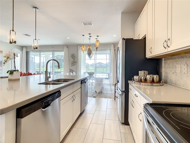 kitchen with white cabinets, dishwasher, sink, and decorative light fixtures