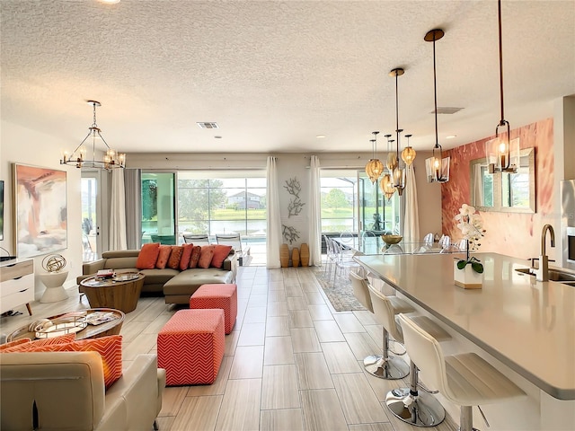 interior space with a chandelier, a textured ceiling, and sink