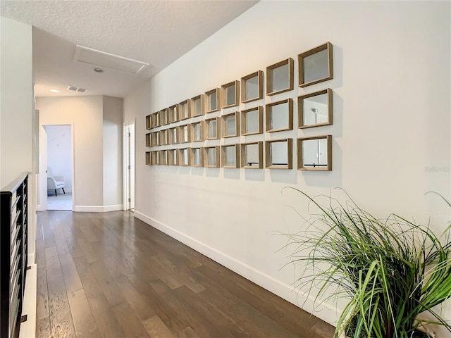 hallway featuring a textured ceiling and dark hardwood / wood-style flooring