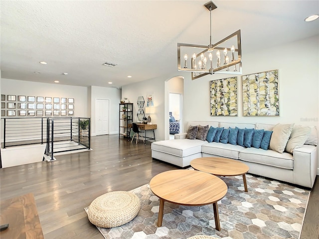 living room featuring wood-type flooring, a textured ceiling, and a chandelier