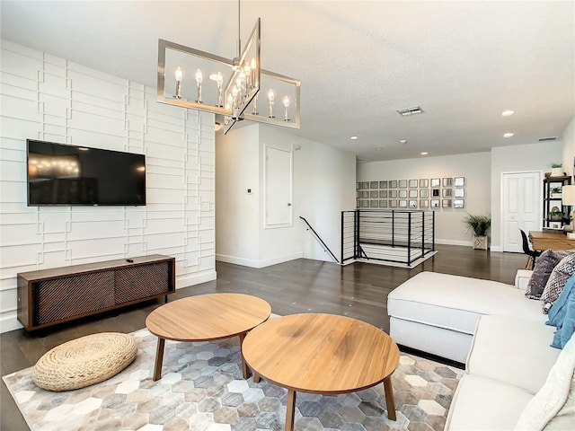 living room featuring a textured ceiling, dark hardwood / wood-style floors, and a notable chandelier