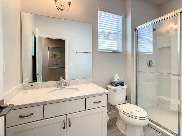 bathroom with walk in shower, vanity, and toilet