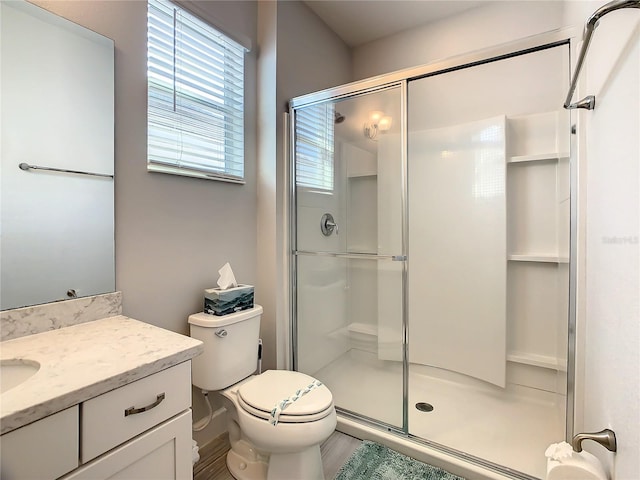 bathroom featuring walk in shower, vanity, and toilet