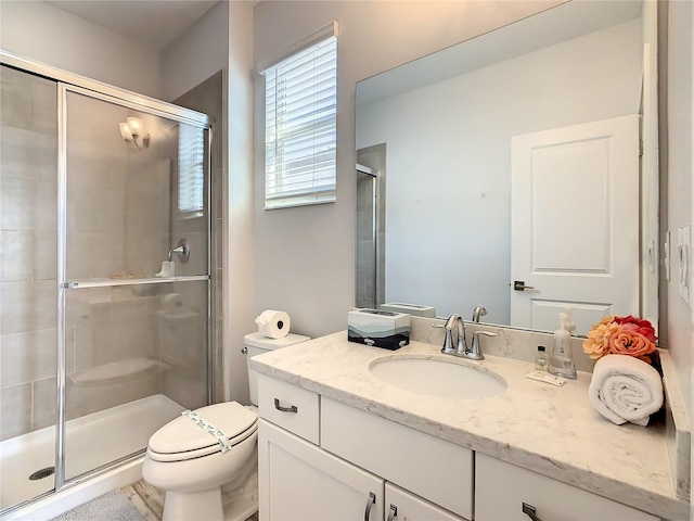 bathroom with vanity, toilet, and an enclosed shower