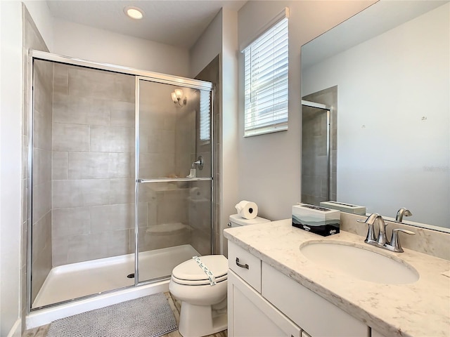 bathroom featuring walk in shower, vanity, and toilet