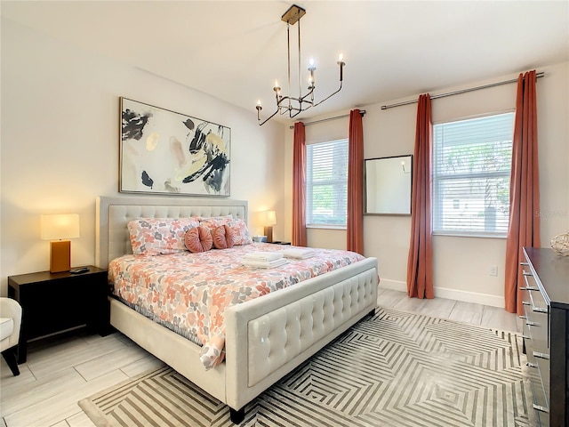 bedroom featuring an inviting chandelier and light hardwood / wood-style flooring