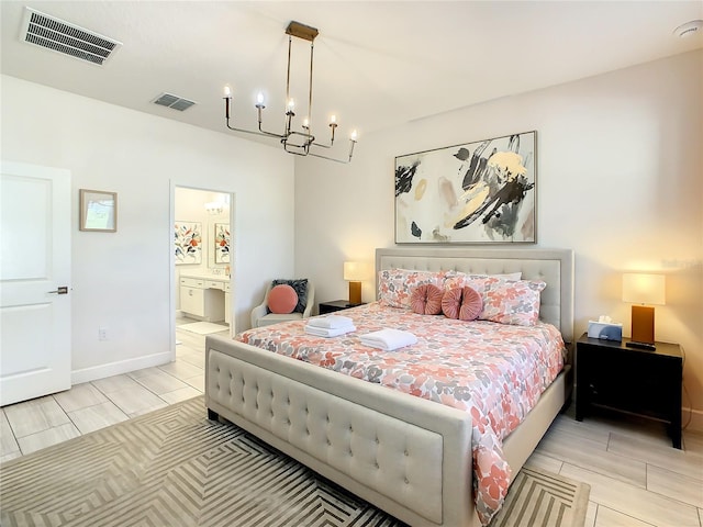 bedroom featuring an inviting chandelier, light hardwood / wood-style flooring, and ensuite bathroom