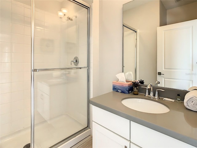 bathroom with walk in shower and vanity