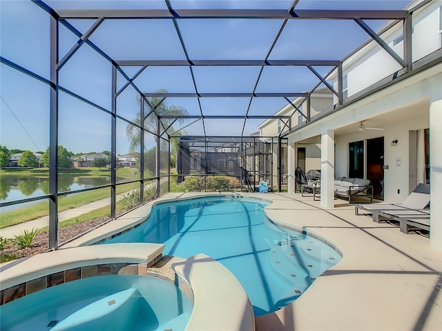 view of pool featuring ceiling fan, a patio, an in ground hot tub, glass enclosure, and a water view