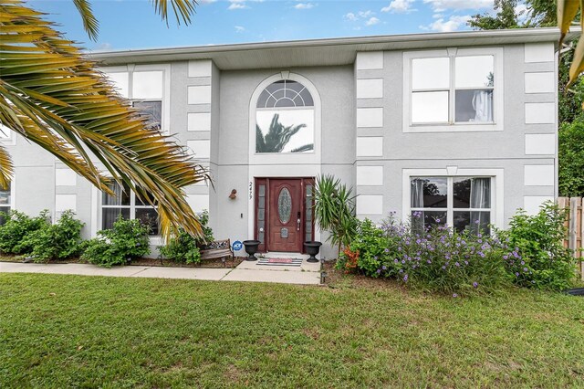 view of front of house featuring a front lawn and stucco siding